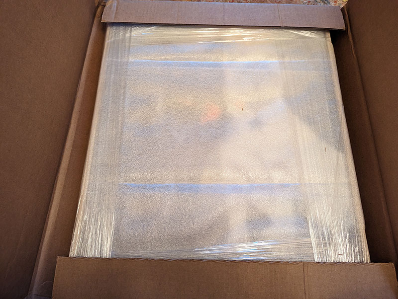 oil painting wrapped in in plastic and padding in the box