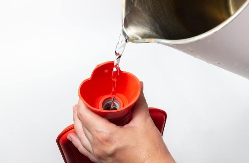 pouring warm water on water bottle