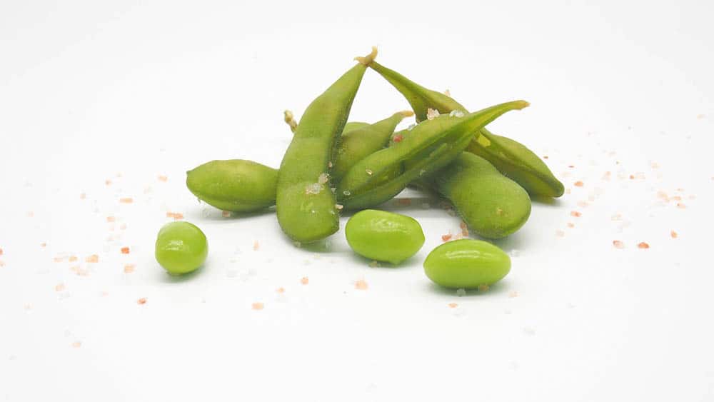 salted edamame on white background