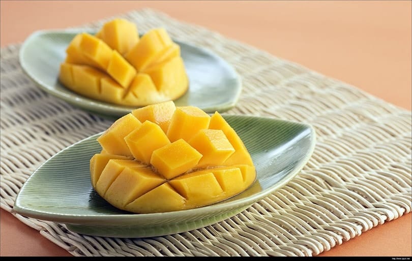 sliced mangoes on leaf-like plates