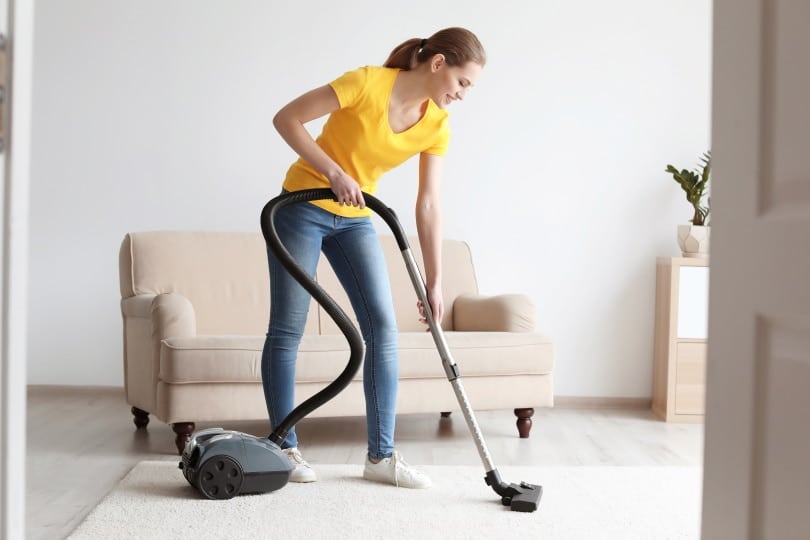 a woman vacuum cleaning the carpet