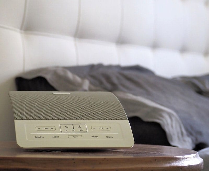 white noise machine on the bedside table