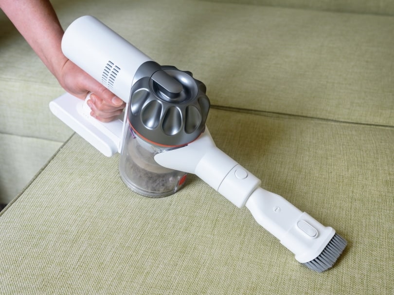 cleaning couch with wireless vacuum cleaner