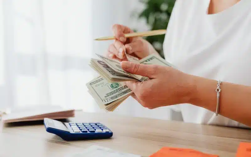 woman counting money with calculator