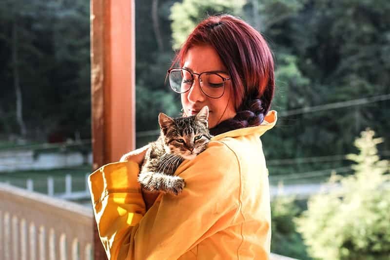 woman holding a cat in the porch