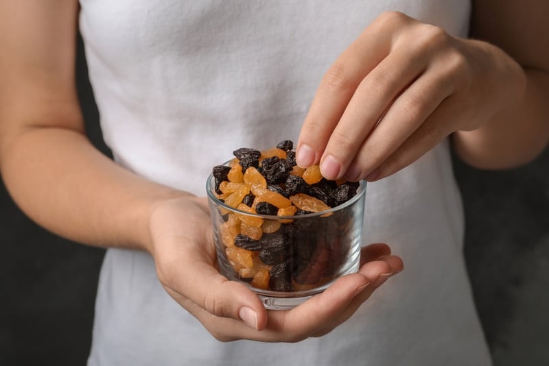 woman holding glass with raisins