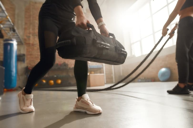 woman lifting a heavy sandbag