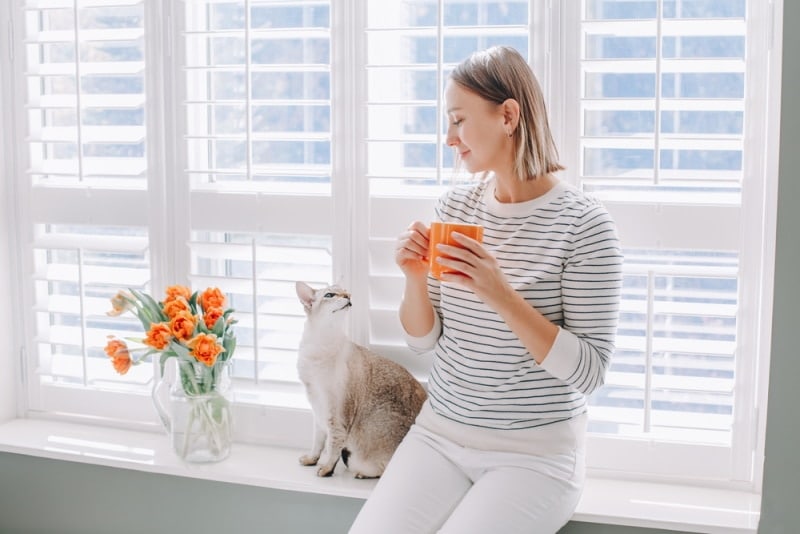 woman sitting beside her cat