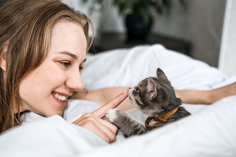 woman smiling in front of adopted kitten