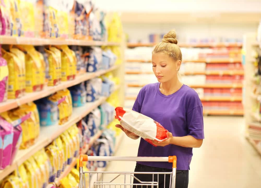 woman-with-a-push-cart-in-grocery-buying-cat-food