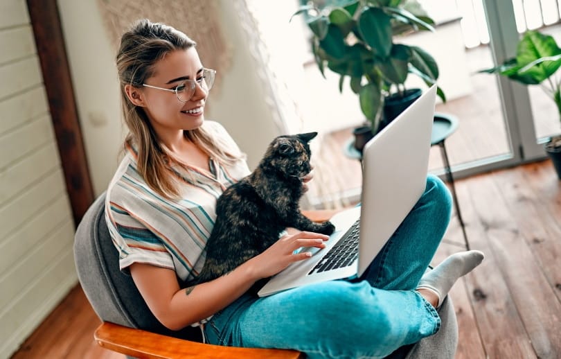 woman with cat using computer