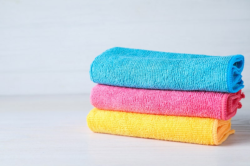 Stack of colorful microfiber cloths on white table