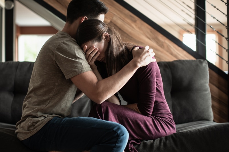 man comforting grieving woman