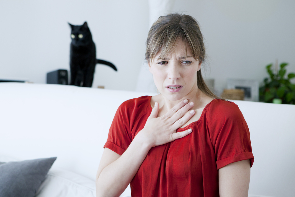 Allergic woman infront of a black cat