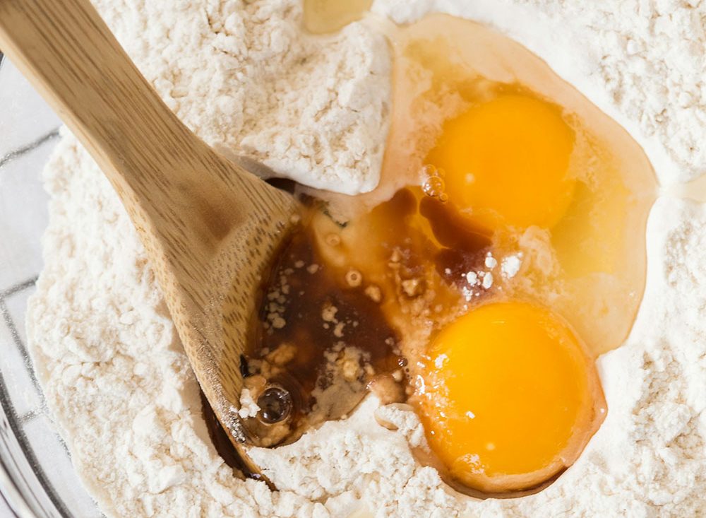 a bowl of flour with eggs