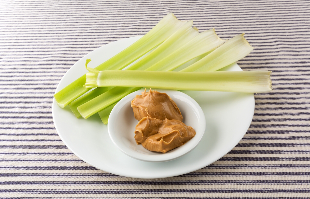 celery-stalks-with-peanut-butter-in-white-plate