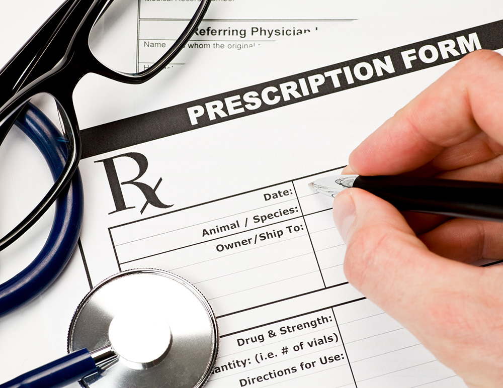 close up doctor filling up a prescription form