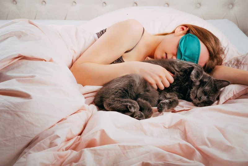woman-sleeping-with-her-cat