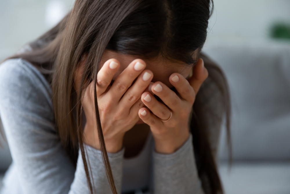 Close up unhappy,crying,guilty,sad young woman hiding face in hands