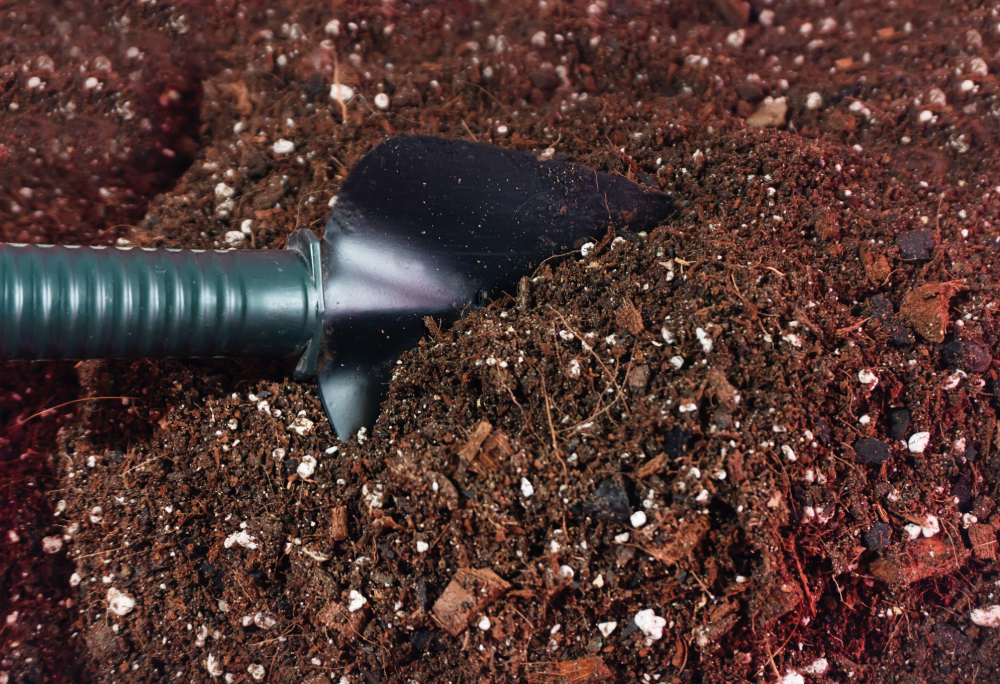 gardener mixing potting soil mix for indoor or container gardening coco husk, perlit with trowel