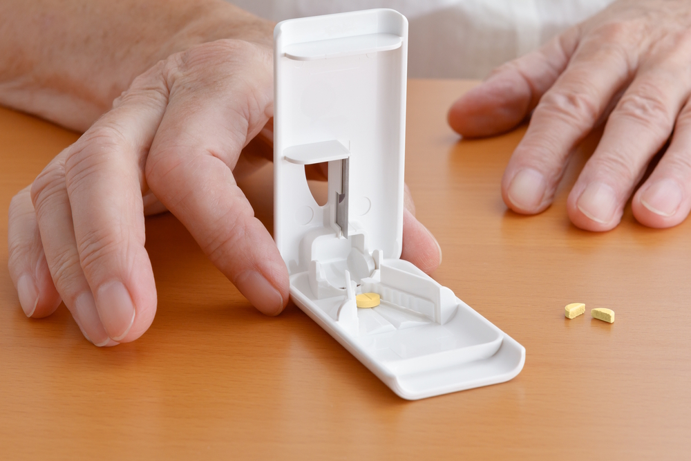 man-using-a-pill-cutter